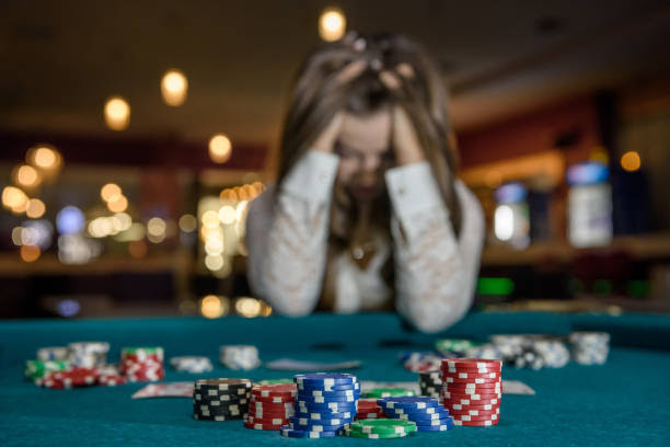 Upset woman in casino sitting behind poker table Upset woman in casino sitting behind poker table Wagerr stock pictures, royalty-free photos & images